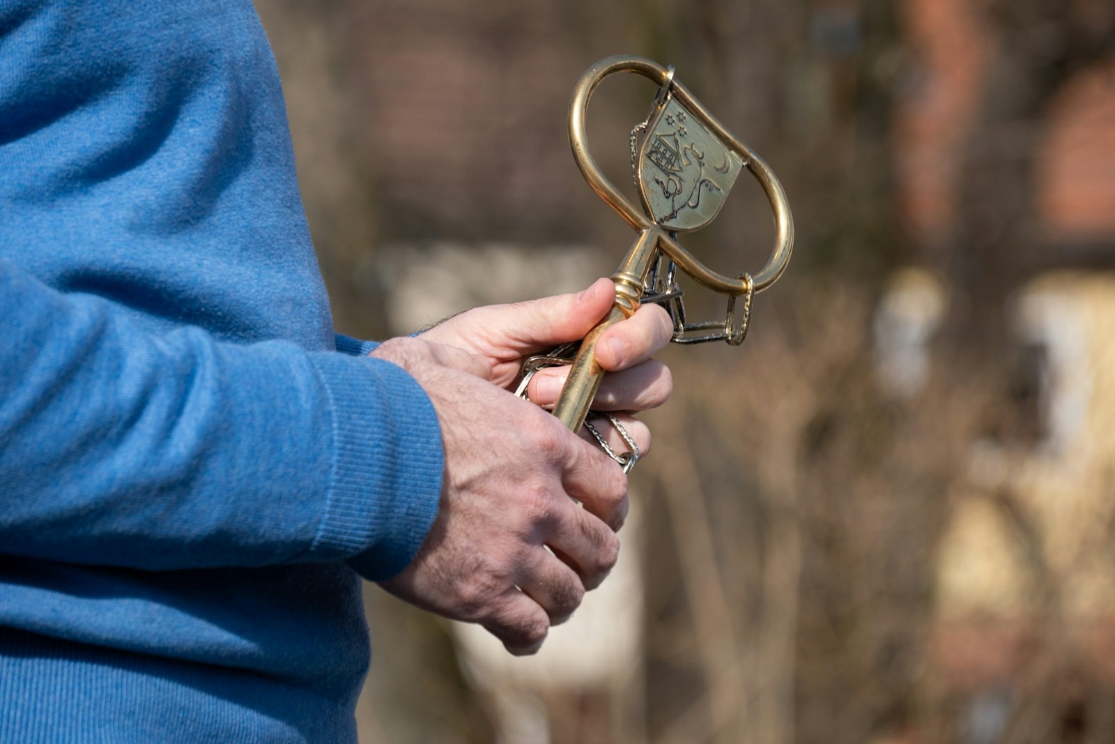 A hand holding a small golden key, supported in an open palm