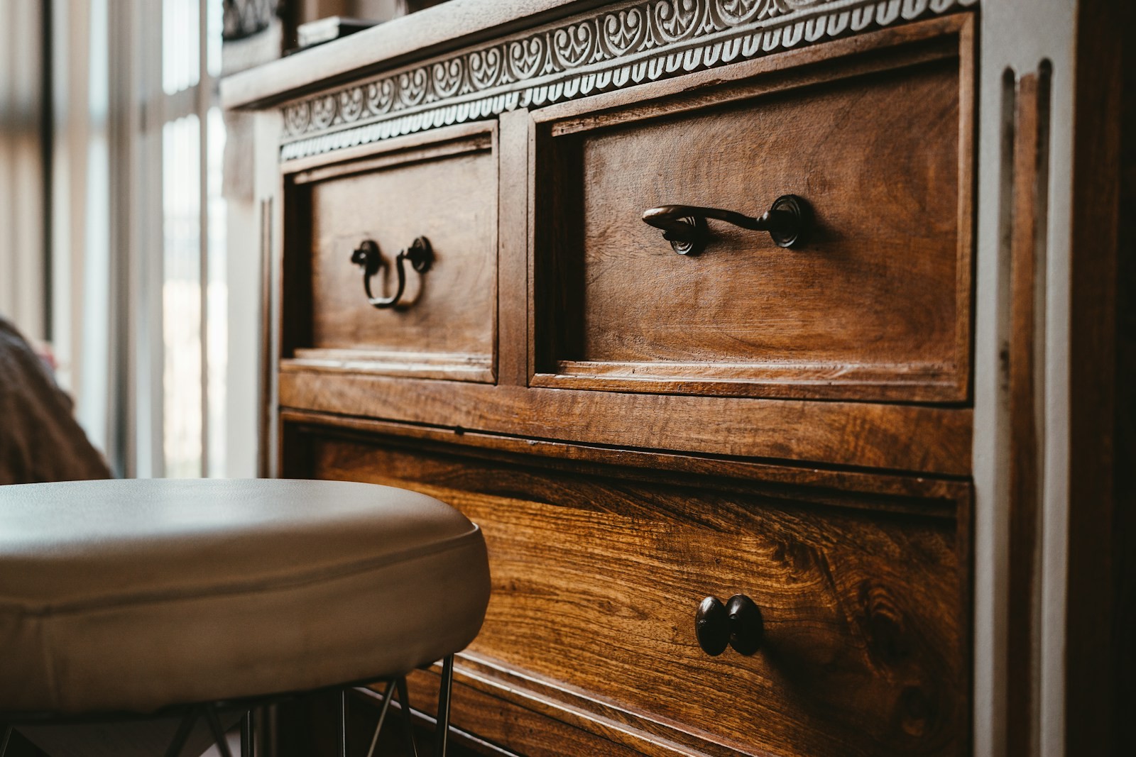 A wooden chest of drawers with visible drawer fronts and handles